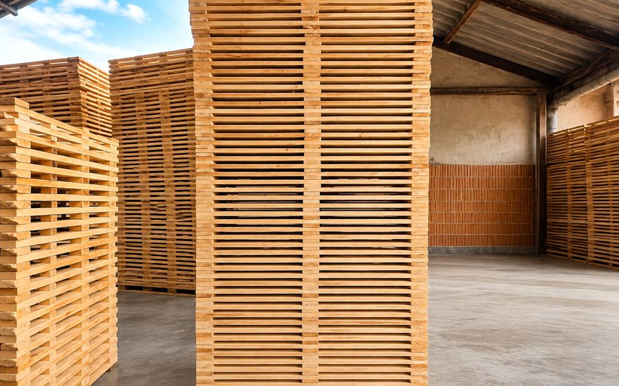 Stacks of nailed pallet decks and bases in a warehouse